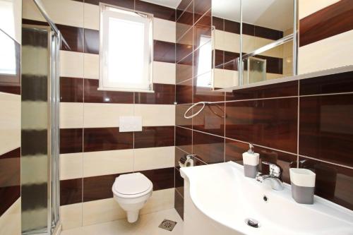 a bathroom with a toilet and a sink at Apartments Gorica 2 in Baška