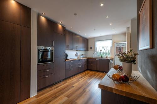 a kitchen with wooden cabinets and a counter with a bowl of fruit at Exclusives 110m2 Ferienhaus Inge mit Garten in Wilhelmshaven