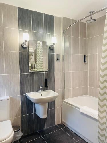 a bathroom with a sink and a toilet and a shower at The Suffolk Hotel in Haverhill