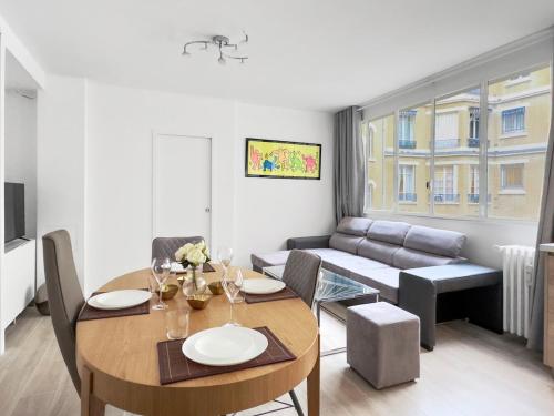 un salon avec une table et un canapé dans l'établissement Charming Apartment 4P- Eiffel Tower Face, à Paris