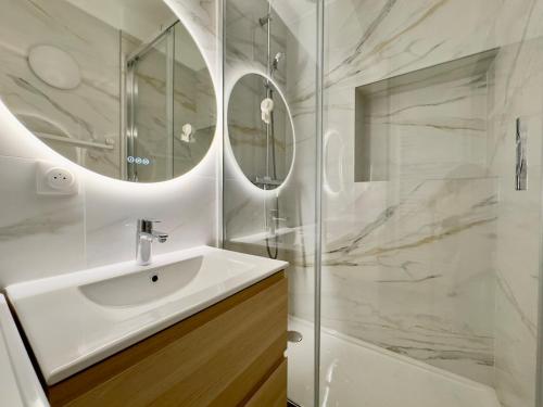 une salle de bain blanche avec un lavabo et une douche dans l'établissement Charming Apartment 4P- Eiffel Tower Face, à Paris