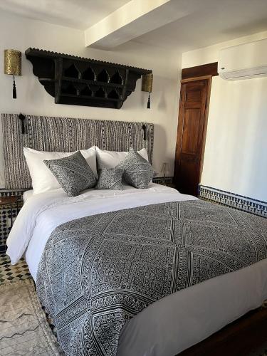 a bedroom with a large bed with pillows at Riad Hanael Garden & Spa in Fès