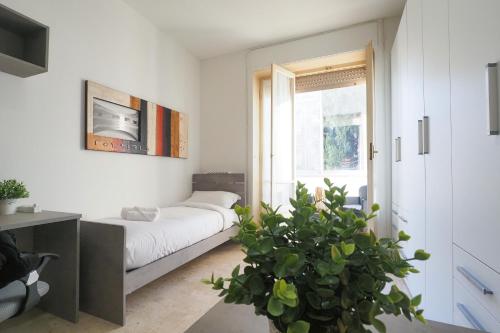 een woonkamer met een bed en een potplant bij PrimoPiano - Cucchi in Milaan
