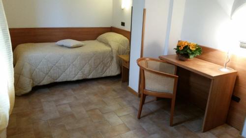 a small room with a bed and a desk and a table at Albergo Vecchio Forno in Spoleto