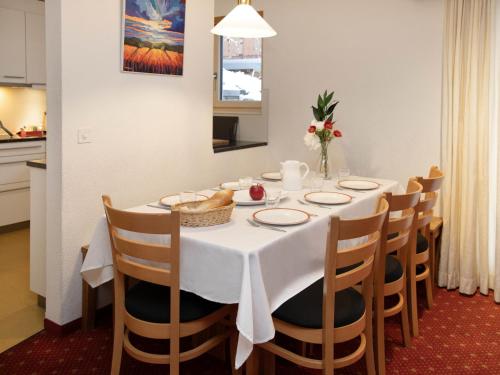 グリンデルワルトにあるApartment Chalet Abendrot apARTments-28 by Interhomeのダイニングルーム(白いテーブルクロスと椅子付)