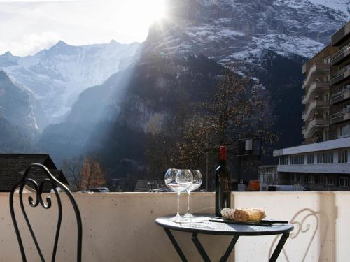 a table with a wine glass and bread on a balcony at Apartment Chalet Abendrot apARTments-15 by Interhome in Grindelwald