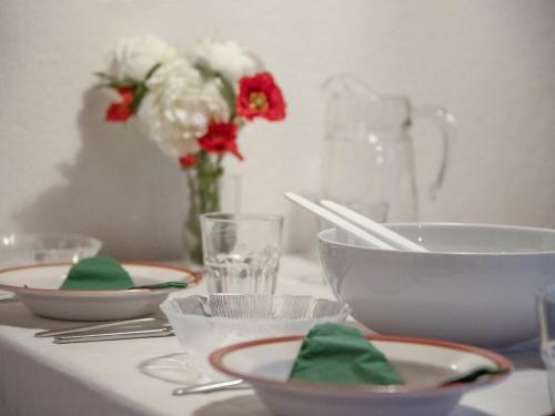 a table with plates and bowls and a vase of flowers at Apartment Chalet Abendrot apARTments-21 by Interhome in Grindelwald