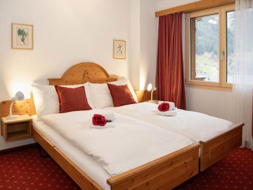a bedroom with a large bed with roses on it at Apartment Chalet Abendrot apARTments-21 by Interhome in Grindelwald