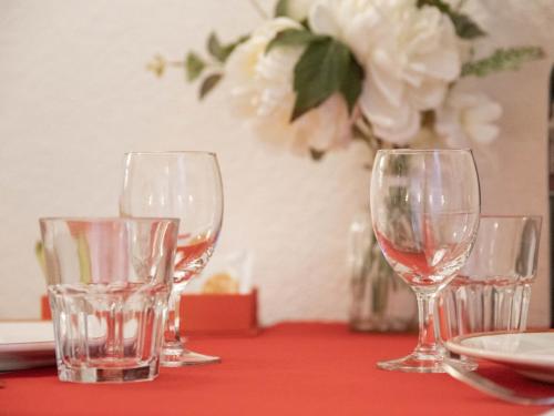 três taças de vinho numa mesa com um vaso de flores em Apartment Chalet Abendrot apARTments-2 by Interhome em Grindelwald