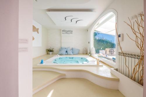 a jacuzzi tub in a room with a large window at Villa Solemare by Raro Villas in Nardò