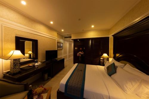 a hotel room with a large bed and a desk at Anpha Boutique Hotel in Ho Chi Minh City