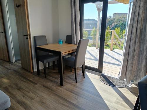 Cette chambre dispose d'un balcon avec une table et des chaises en bois. dans l'établissement Mobile-home bord de mer, au Guilvinec