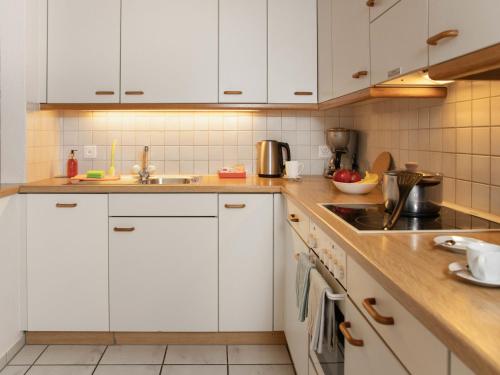 a kitchen with white cabinets and a sink at Apartment Chalet Abendrot apARTments-27 by Interhome in Grindelwald