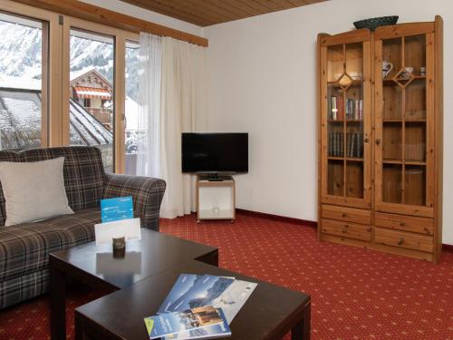 a living room with a couch and a tv at Apartment Chalet Abendrot apARTments-27 by Interhome in Grindelwald