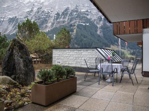 a patio with a table and chairs and a mountain at Apartment Chalet Abendrot apARTments-27 by Interhome in Grindelwald