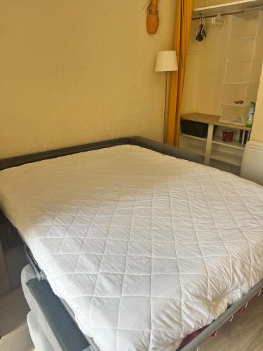 Ce lit se trouve dans un dortoir doté d'un matelas. dans l'établissement Studio climatisé avec entrée privée- 5 min des plages, sur les hauteurs de Cavalaire, à Cavalaire-sur-Mer