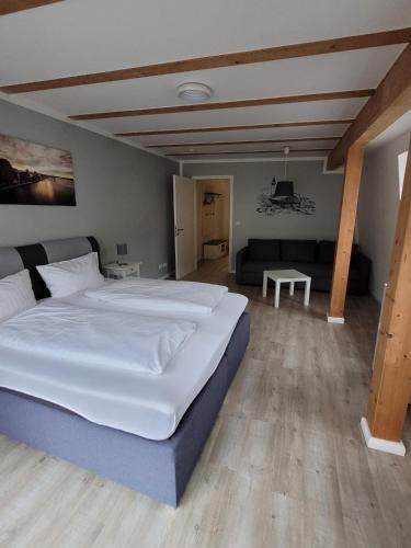 a bedroom with a large bed and a living room at Altstadtpension Rostock in Rostock