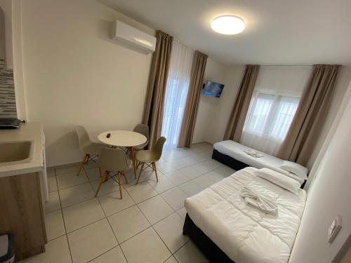 a small room with a bed and a table and a kitchen at Sunny Beach Potos in Potos