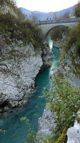 a bridge over a river with blue water underneath at Studio Brnat in Kobarid