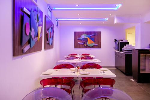 a row of tables in a room with red chairs at Amorgos Boutique Hotel in Larnaka