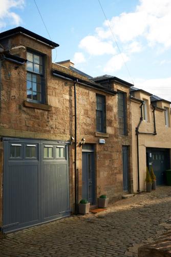 a brick house with a gray garage at Park Mews Glasgow in Glasgow