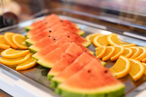 a tray of sliced fruit with oranges and watermelon at Hotel Tauernglöckl in Obertauern