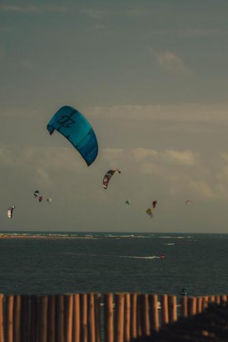 a group of kites flying over the ocean at Jaguaríndia Village in Fortim