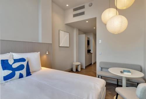 a bedroom with a bed and a table and a chair at Hotel Kobalt - Den Haag in The Hague