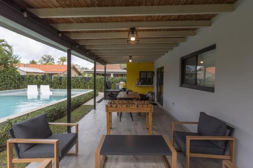 a patio with a table and chairs and a pool at Heated pool - 5min Coral Gables - Family Vacation in Miami