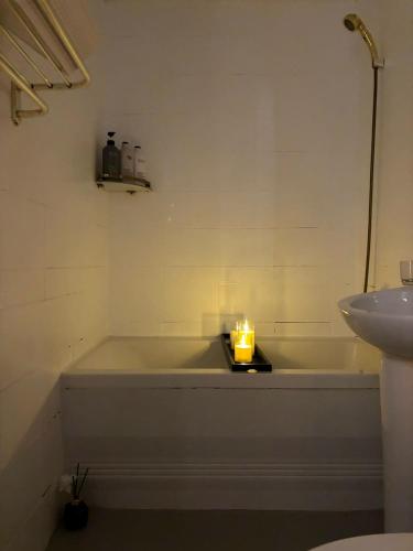 a bathroom with a bath tub with a candle on a tray at Sillim Leo's House in Seoul