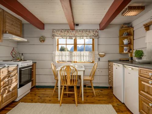una cucina con tavolo, sedie e finestra di Chalet Eiketun by Interhome a Olden