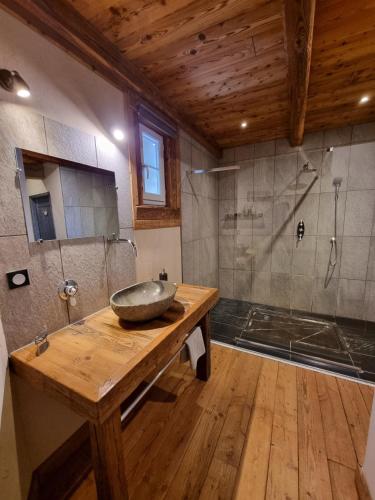 une salle de bain avec un lavabo en pierre et une douche dans l'établissement Chambres d'hôtes Le St Maurice, à Truinas