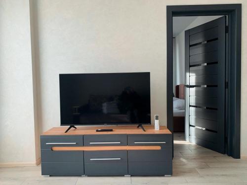 a living room with a television on a dresser at Apartmets Domovik Мира 11с кв 7 Вместительная трёхкомнатная квартира in Mukacheve
