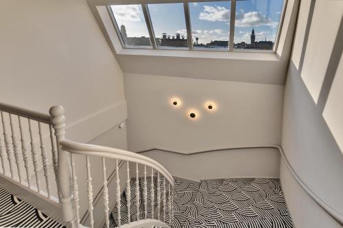 a staircase with a white crib and a window at Hotel Kobalt - Den Haag in The Hague
