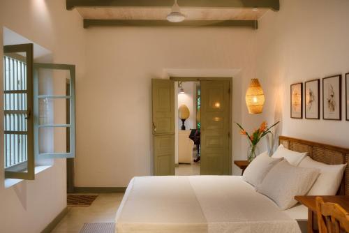 a bedroom with a white bed and a hallway at Sukomala Imaduwa in Ahangama