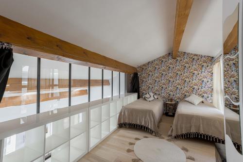 - une chambre avec 2 lits et un mur de fenêtres dans l'établissement Loft Meynadier by Halldis, à Cannes