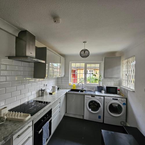 a kitchen with a sink and a washing machine at Modern Spacious Rooms 10 Minutes from London Eye in London