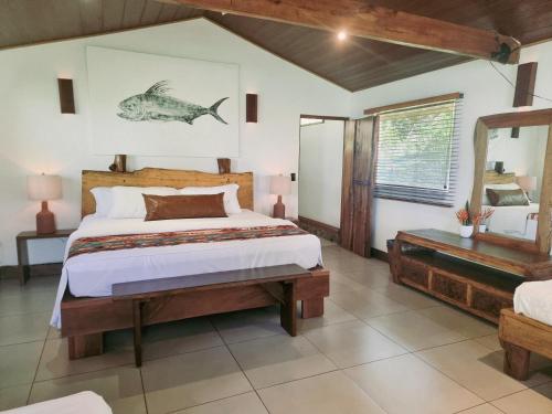 a bedroom with a bed and a fish picture on the wall at The Jaguars Jungle Rainforest Lodge - All meals included in San Pedrillo