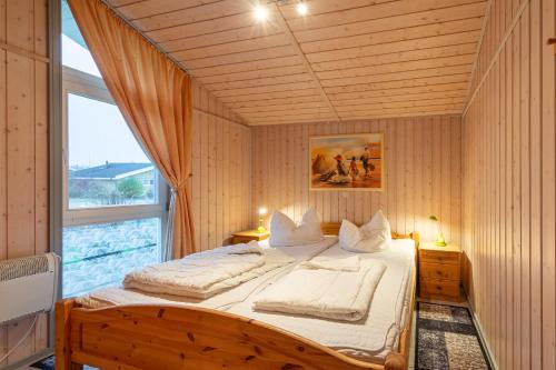 a bed in a room with a large window at Seeschwalbe 54 in Rechlin