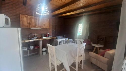 eine Küche und ein Esszimmer mit Tisch und Stühlen in der Unterkunft Harmonia suite de campo- Rincón de Afrodita in San Lorenzo