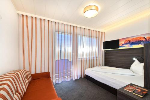 a hotel room with a bed and a window at Hotel Tyrol Plose in Bressanone