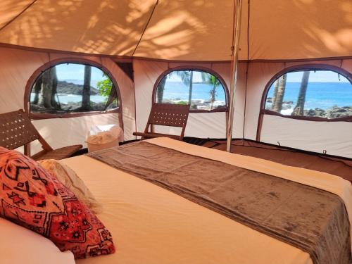 a room with a bed in a tent with three windows at The Jaguars Jungle Rainforest Lodge - All meals included in San Pedrillo