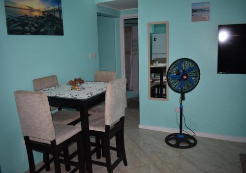 a dining room with a table and chairs and a fan at Cherie Daze in Corinthe