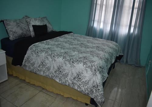 a blue bedroom with a bed with a gray comforter at Cherie Daze in Corinthe