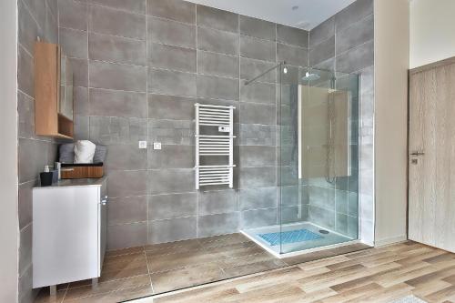 une salle de bain avec une douche avec une porte vitrée dans l'établissement L'Appart Chic - Terrasse - Proche Lyon & tram, à Villeurbanne