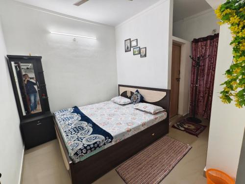 a small bedroom with a bed and a mirror at ZTRIO Vacations in Chikmagalūr