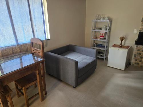 a living room with a couch and a table at Reserva da Mata Suites in Brumadinho