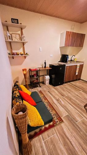 a living room with a couch and a kitchen at Acogedor estudio frente al mar con aire acondicionado in Moñitos