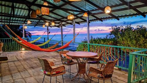 a patio with a hammock and a table and chairs at Acogedor estudio frente al mar con aire acondicionado in Moñitos