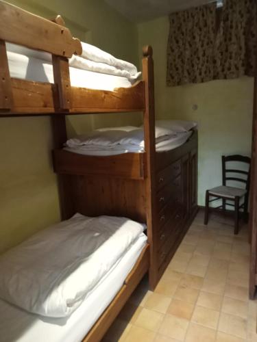 a bedroom with two bunk beds and a chair at Residenza dei Maestri in Roccaraso